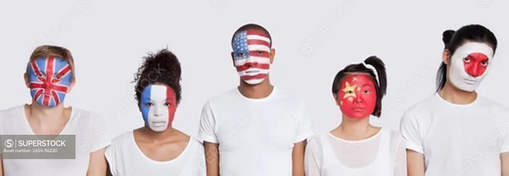 London, UK. Portrait of multi_ethnic group with various national flags painted on face against white background