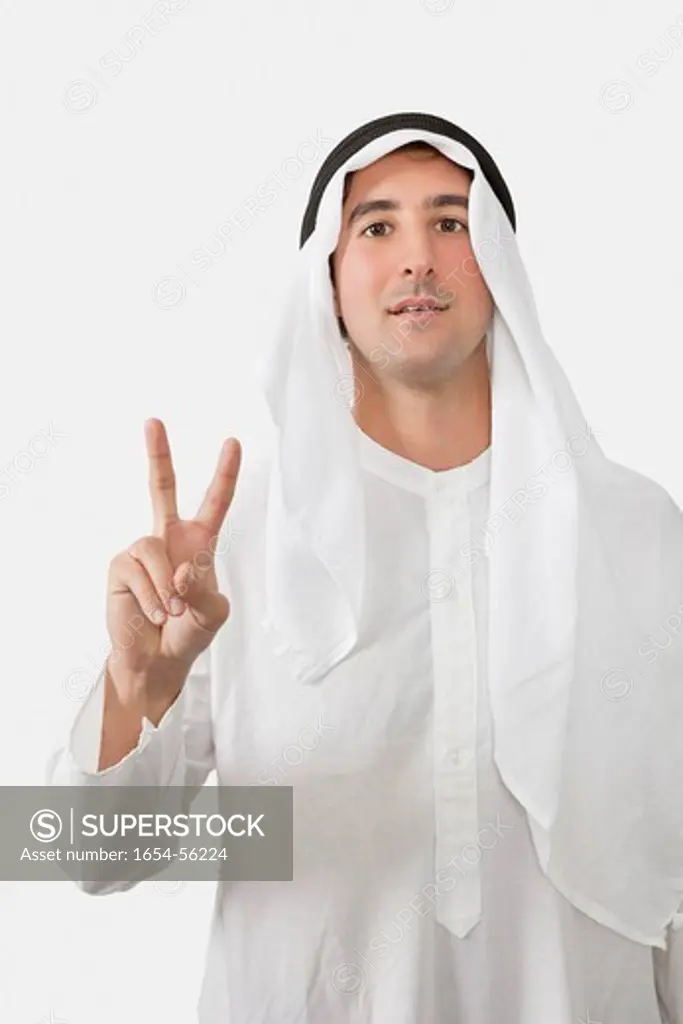 London, UK. An Arab man gesturing V_sign over white background