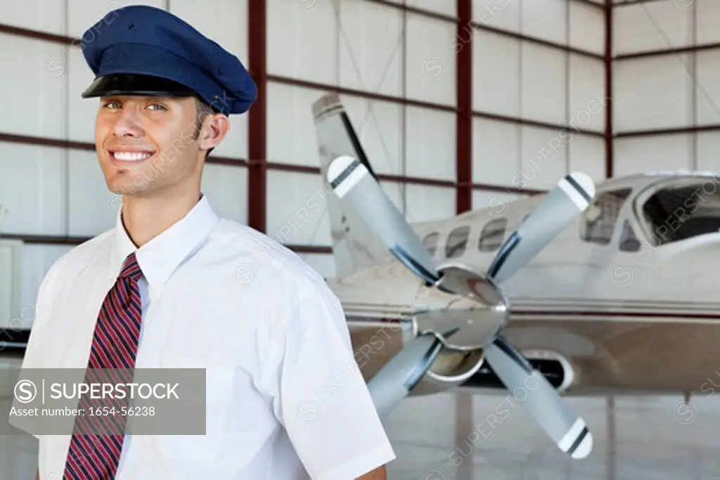 Palm Springs, California, USA. Portrait of happy young male pilot standing in front of airplane
