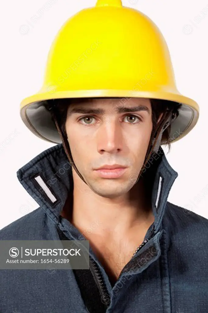London, UK. Portrait of young fireman against gray background