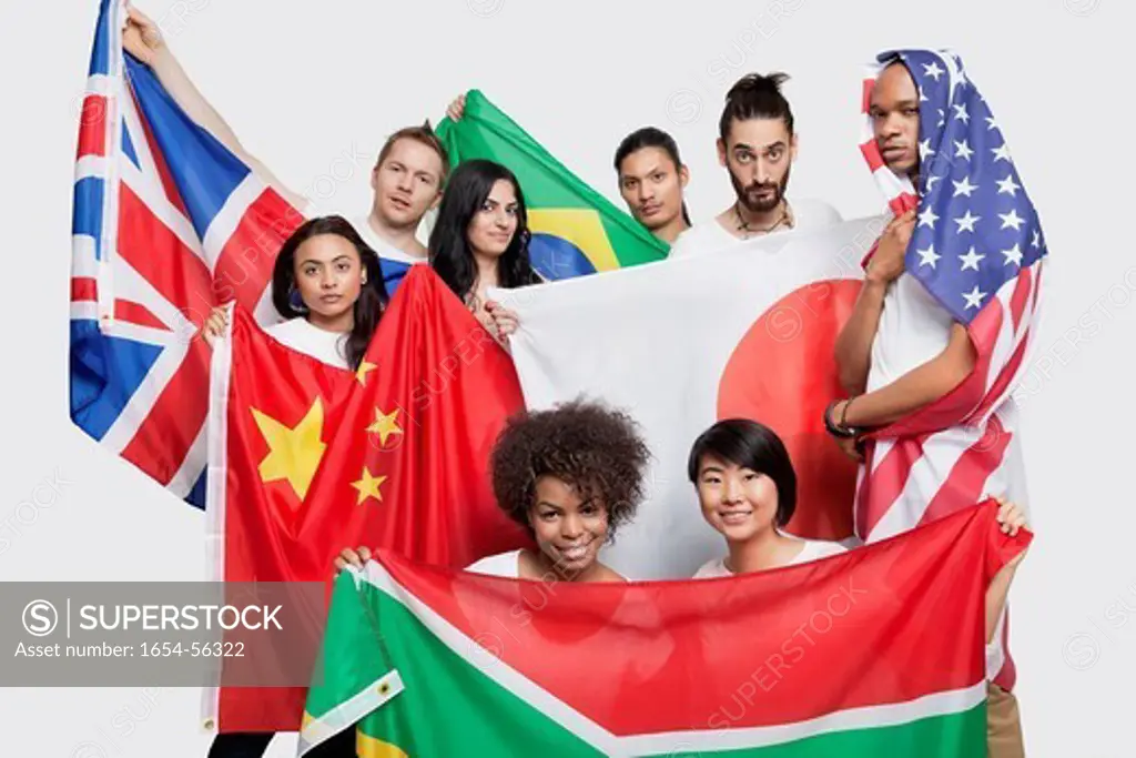 London, UK. Group of multi_ethnic friends posing with various national flags against white background