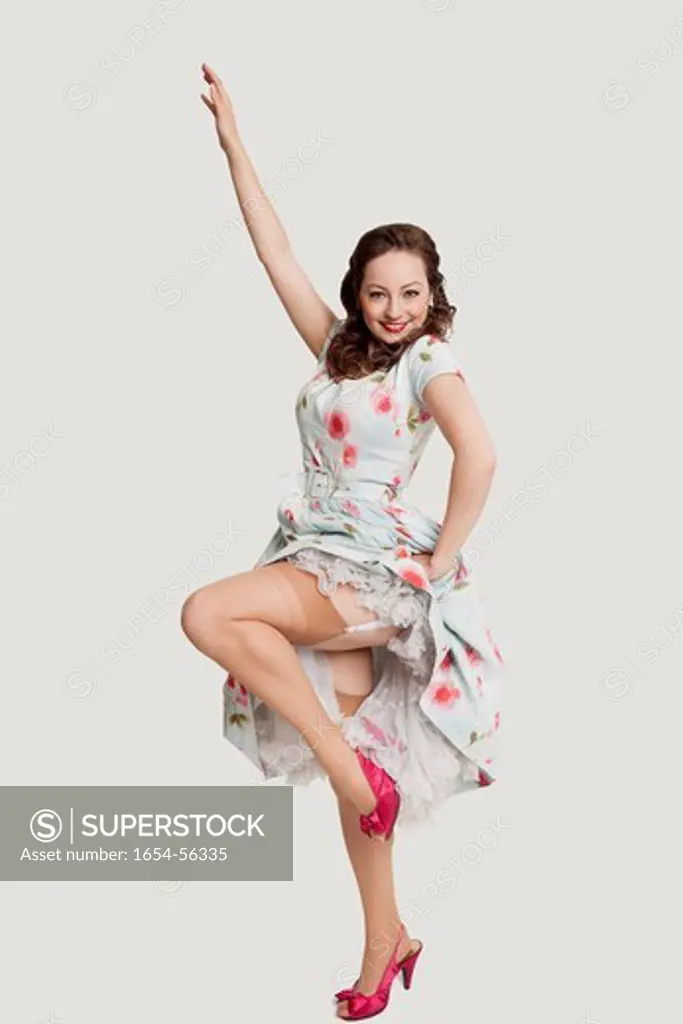 London, UK. Portrait of fashionable young woman in dress posing against white background