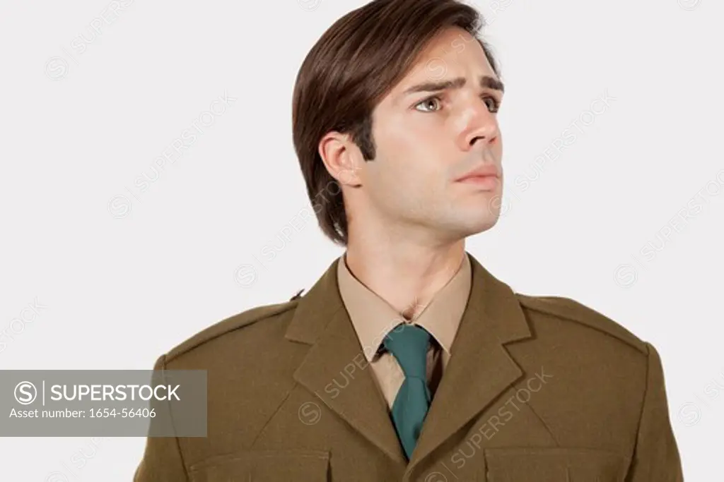 London, UK. Young man in military uniform looking away against gray background