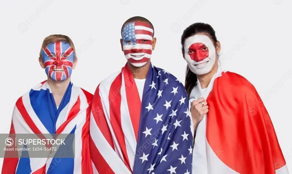 London, UK. Portrait of young patriotic men with national flags and face painting smiling against white background