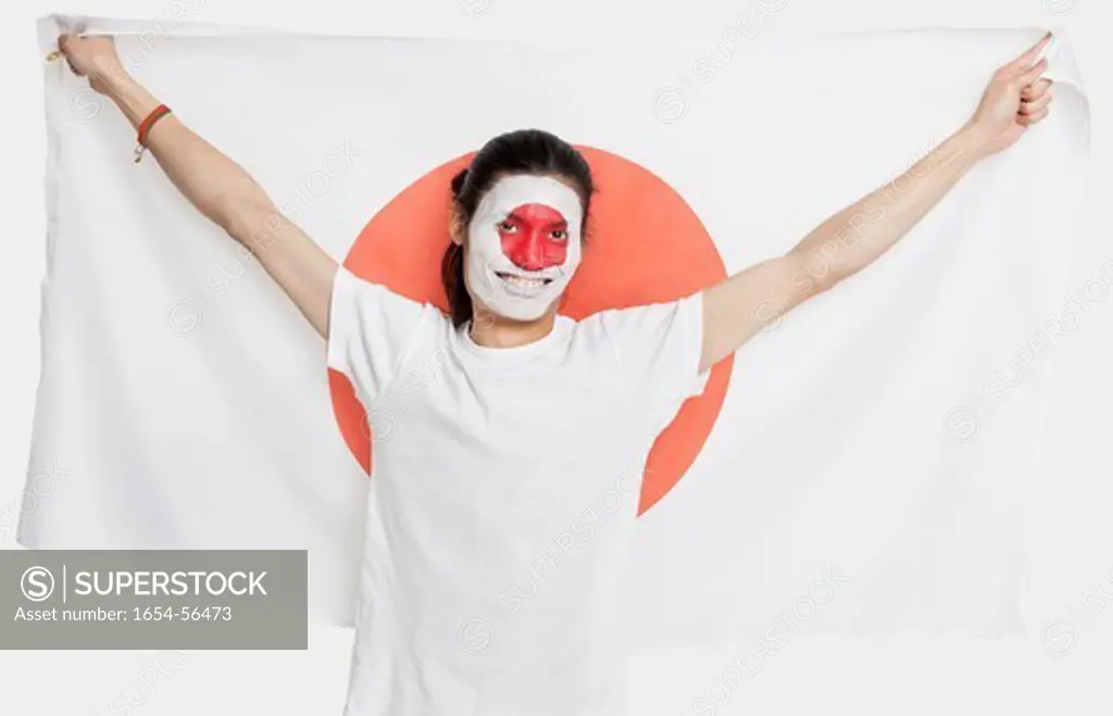 London, UK. Portrait of young Asian man with Japanese flag smiling against white background
