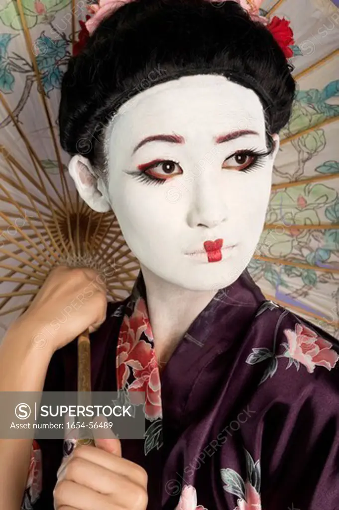 Palm Springs, California, USA. Close_up of Japanese woman with painted face holding parasol