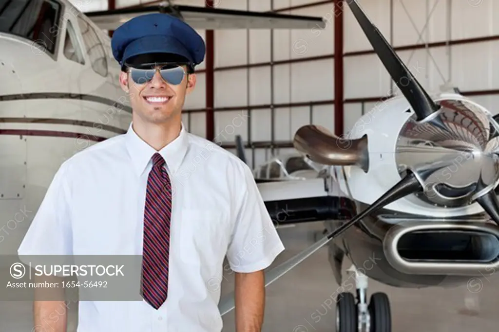 Palm Springs, California, USA. Portrait of handsome young pilot standing in front of airplane