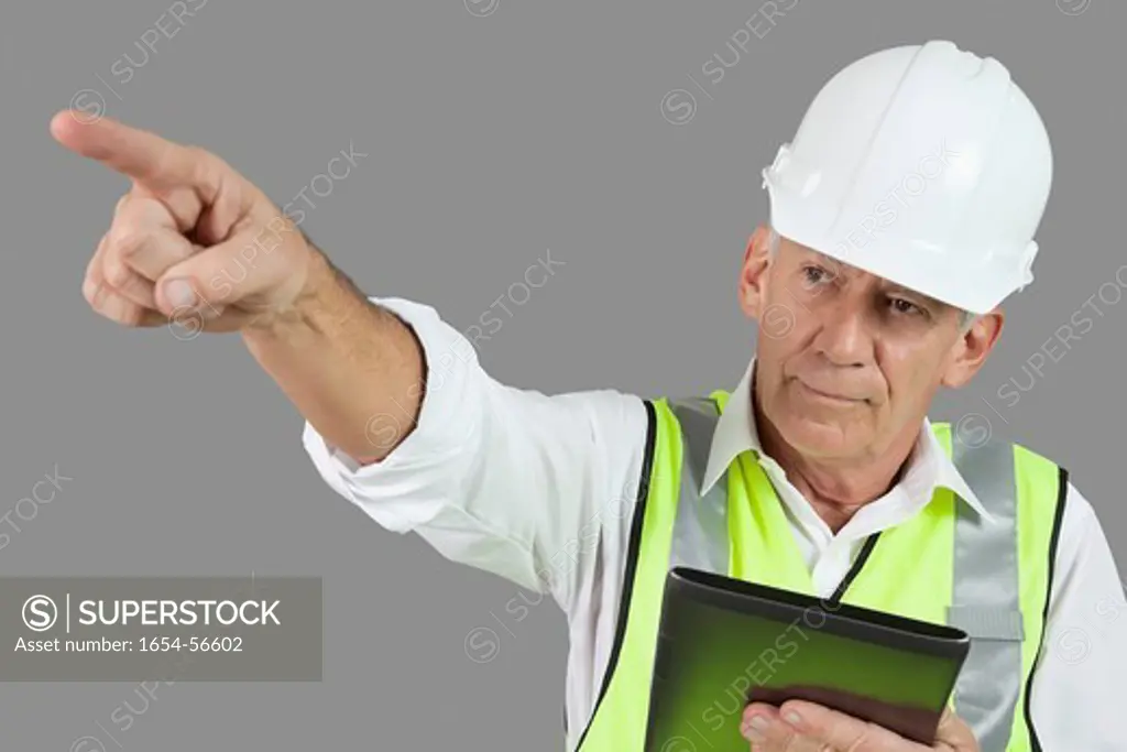Palm Springs, California, USA. Portrait of male construction worker with tablet PC pointing over gray background