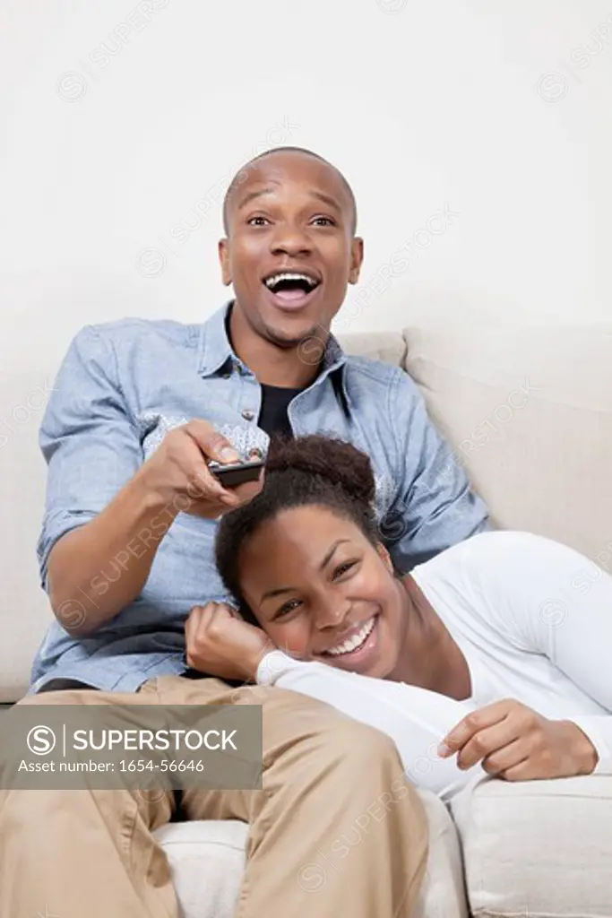 London, UK. Excited young African American couple watching TV