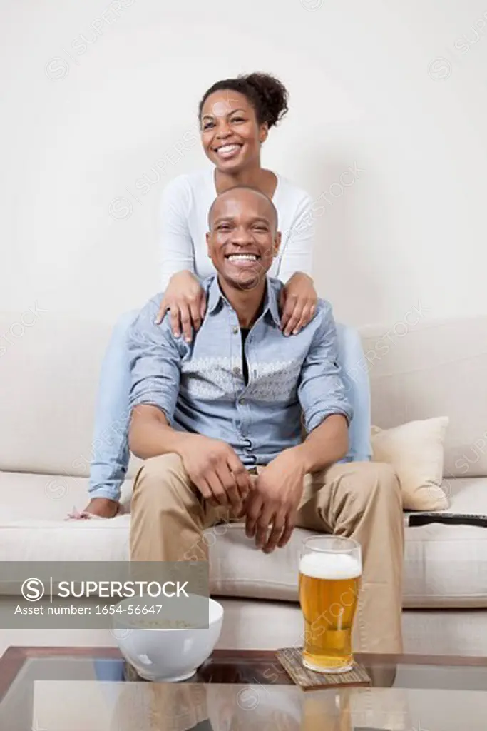 London, UK. Portrait of excited young African American couple watching TV