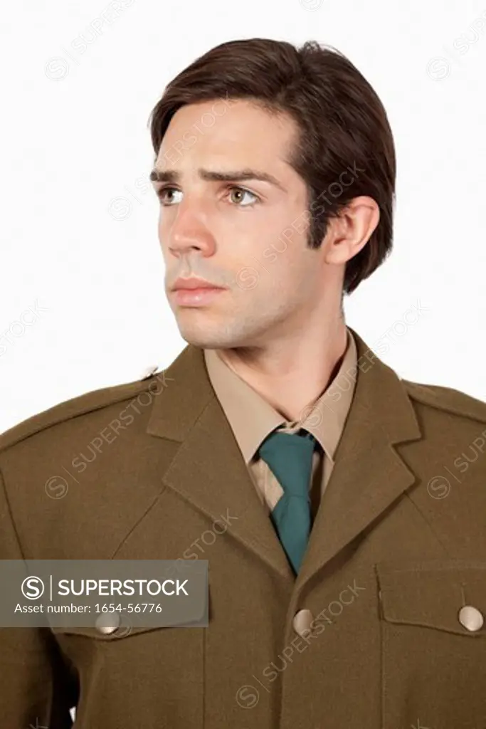 London, UK. Thoughtful man in military uniform looking away against gray background