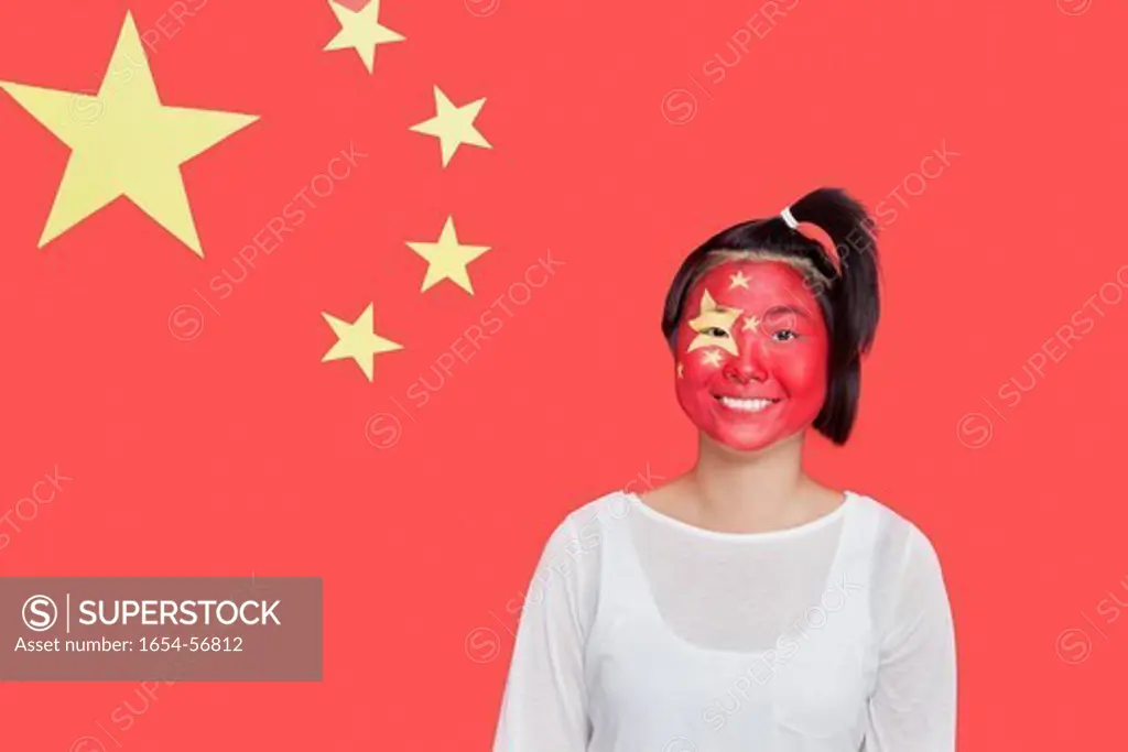 London, UK. Portrait of young Asian woman with painted face smiling against Chinese flag