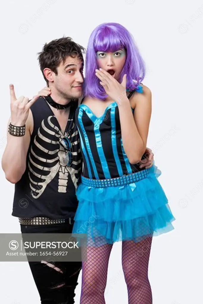 London, UK. Portrait of young punk man with surprised young woman over white background