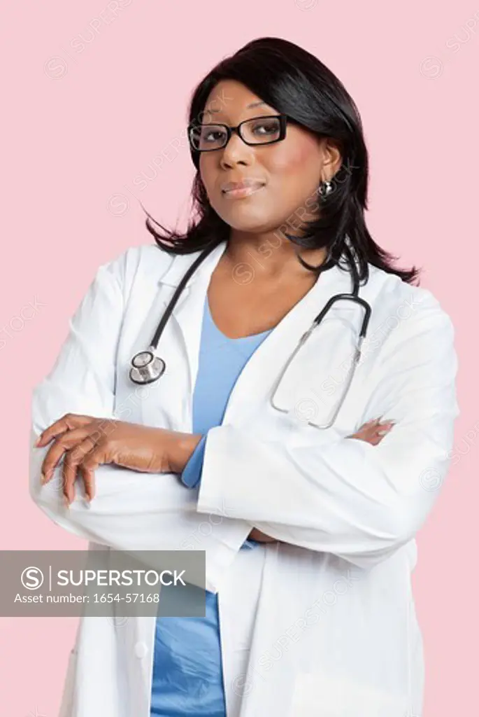 London, UK. Portrait of confident mixed race female surgeon over pink background