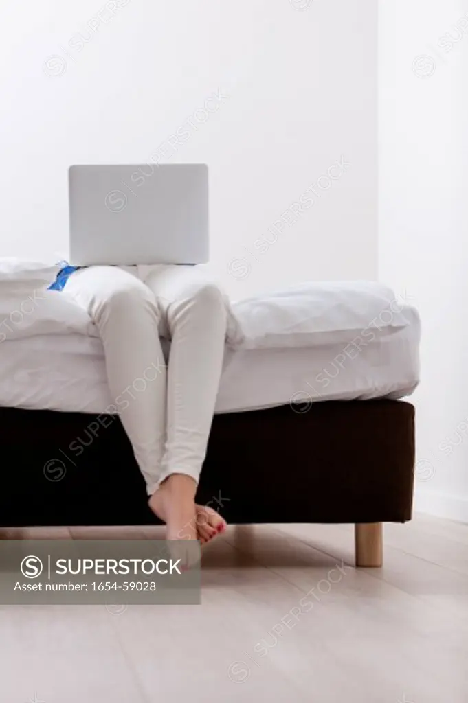 Close-up view of Woman using laptop on her bed