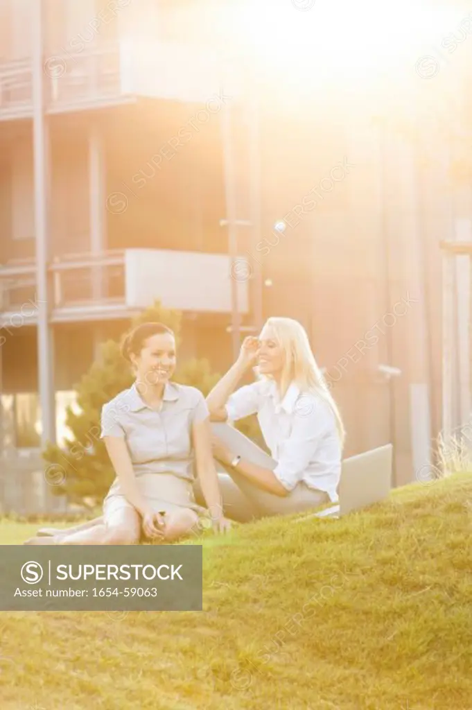 Young businesswomen gossiping in office lawn