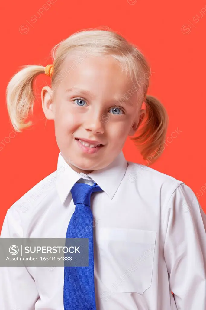 Portrait of a cute young girl in school uniform over blue background
