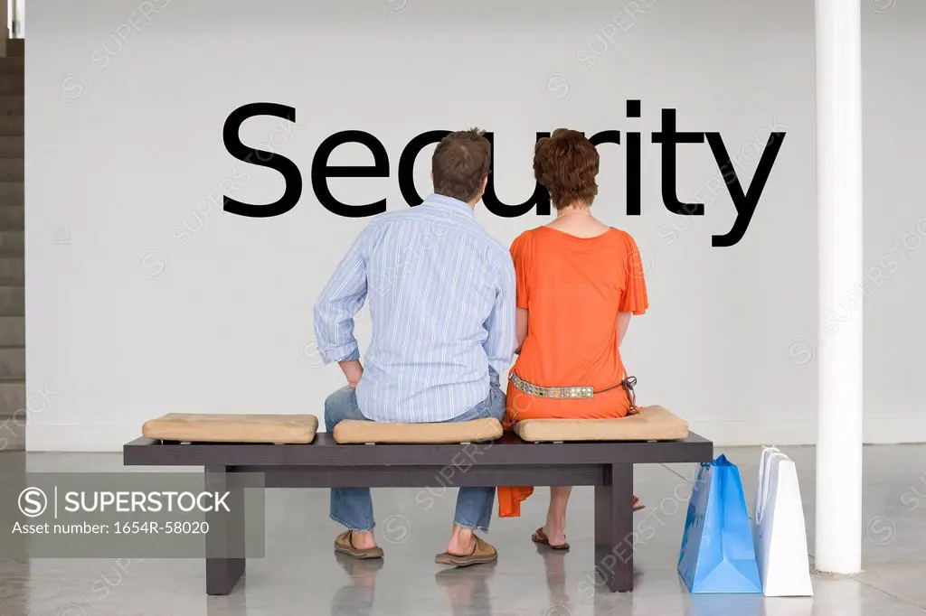 Rear view of couple seated on bench contemplating about future security