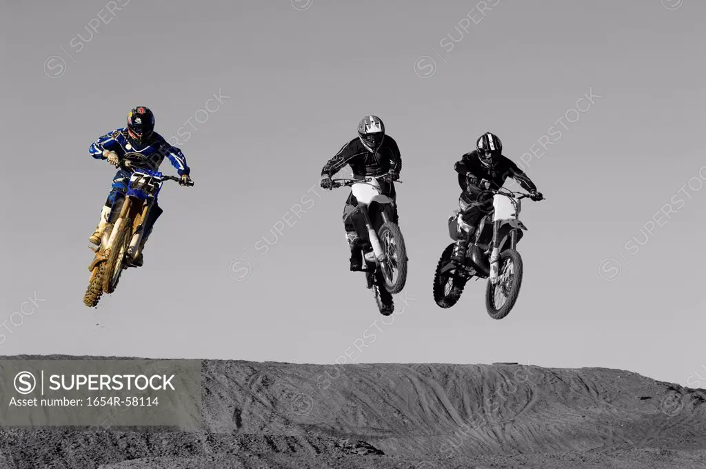 Young motocross racers riding on dirt track