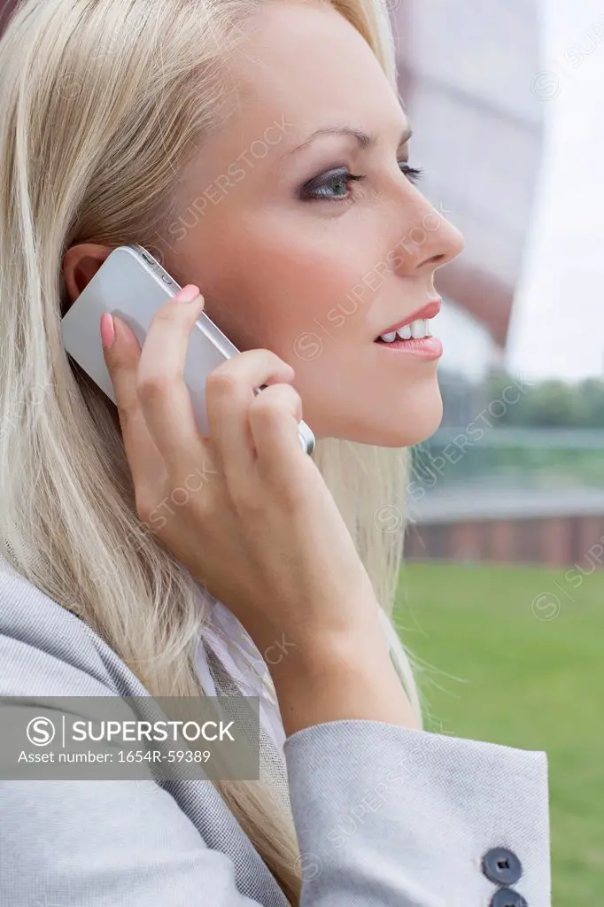 Side view close-up of young businesswoman using mobile phone
