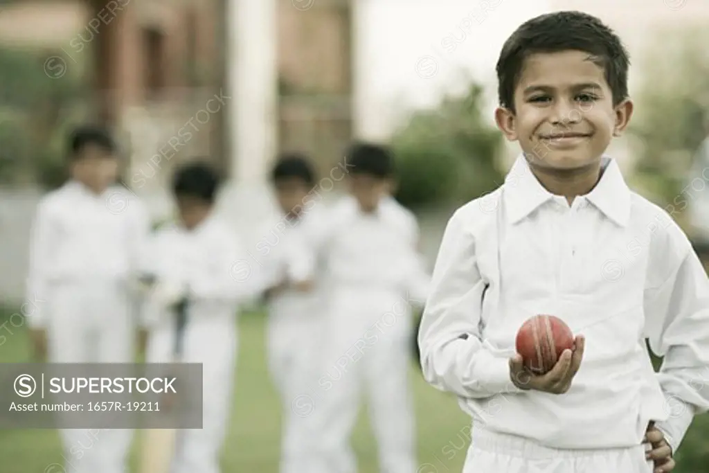 Cricketer holding a cricket ball and smiling