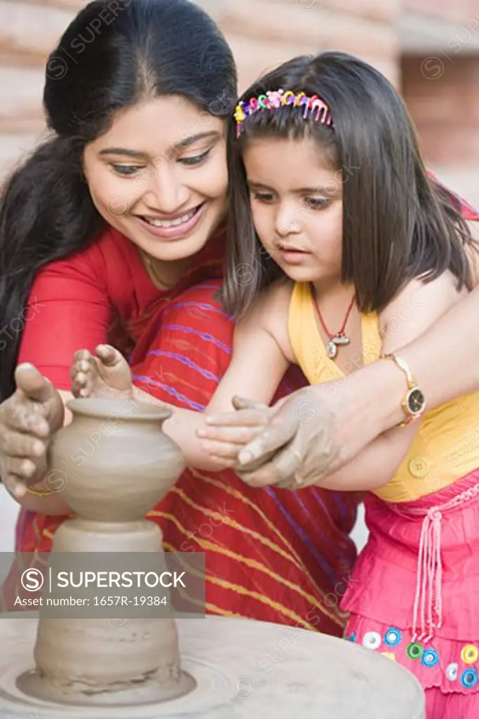 Girl with her teacher in a pottery class