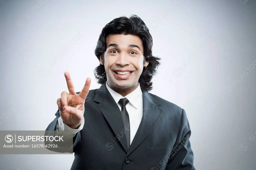 Businessman showing victory sign