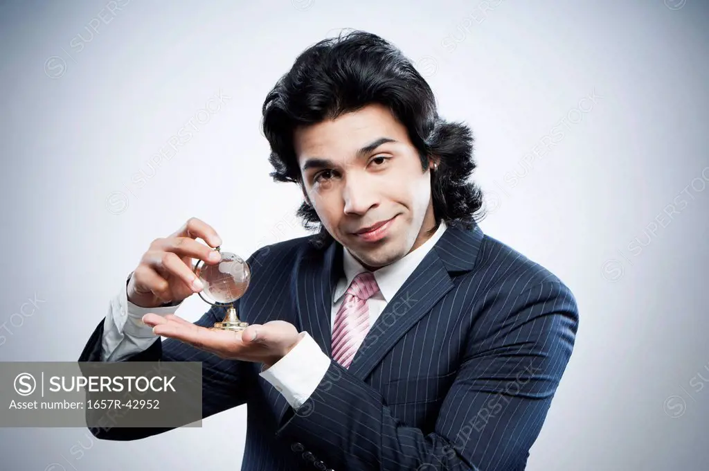 Businessman holding a small crystal globe