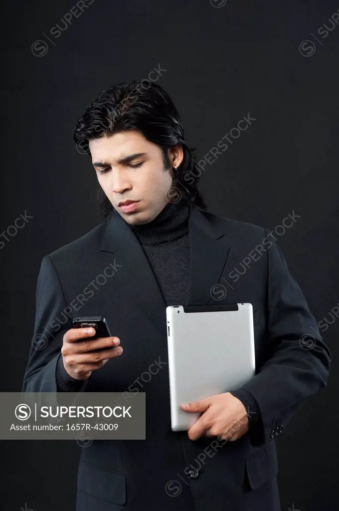 Businessman holding a digital tablet and using a mobile phone