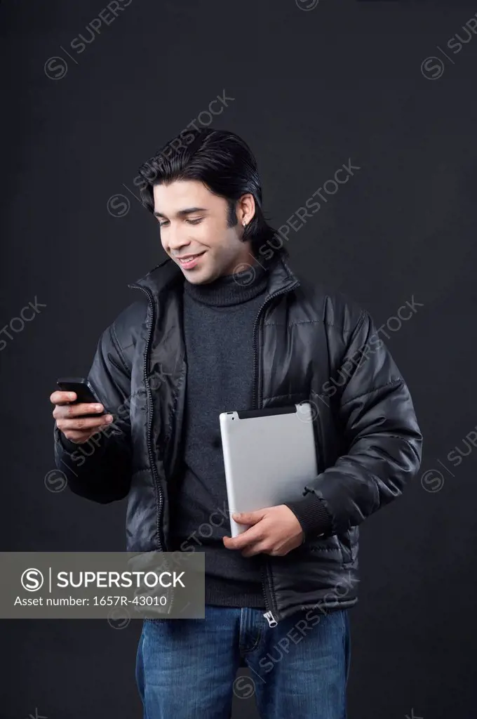 Man holding a digital tablet and using a mobile phone