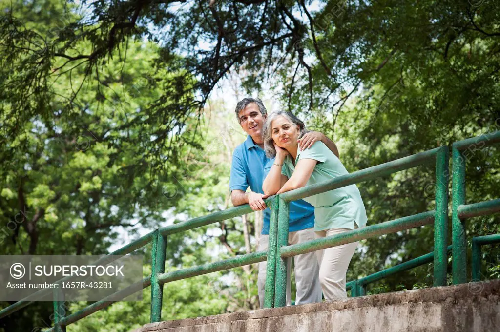 Mature couple standing on a footbridge, Lodi Gardens, New Delhi, India