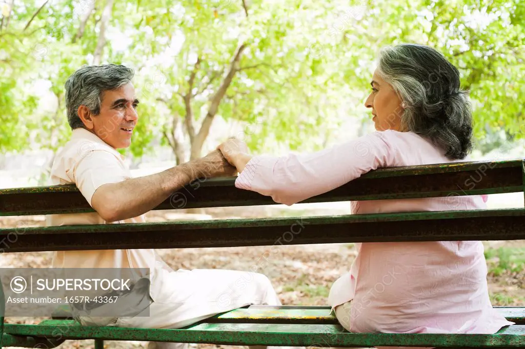 Mature couple sitting on a park bench, Lodi Gardens, New Delhi, India
