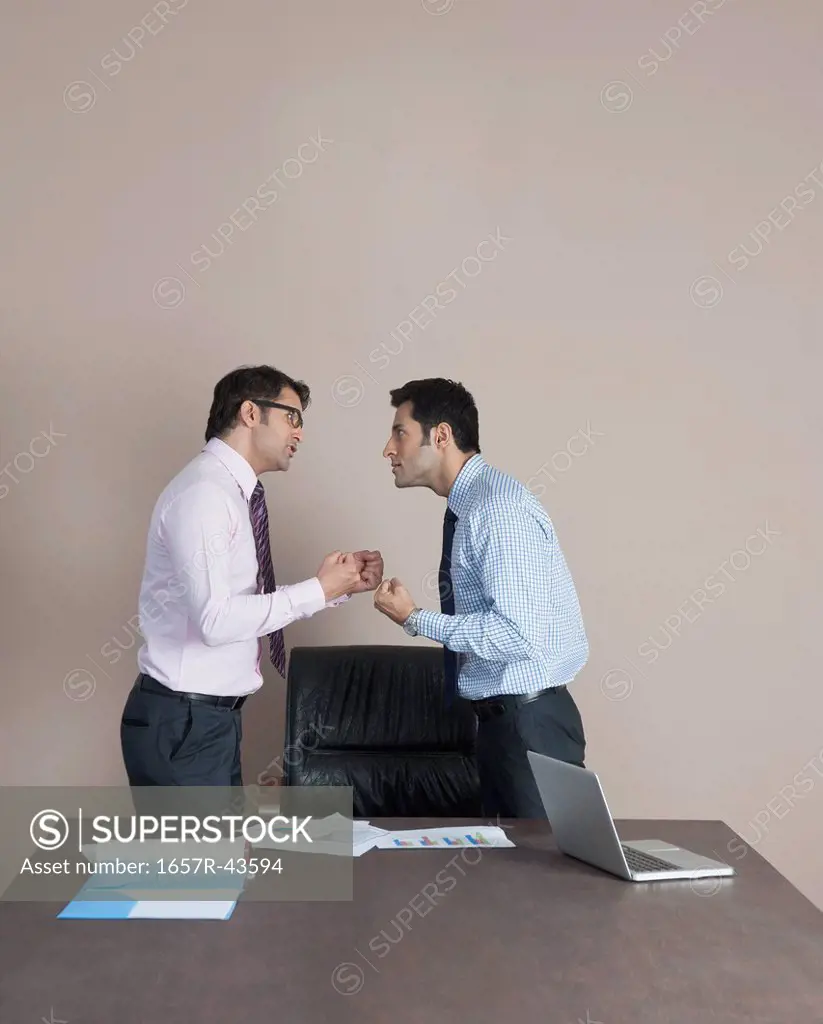 Two businessmen fighting to each other