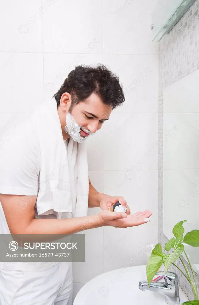 Man shaving his face in the bathroom