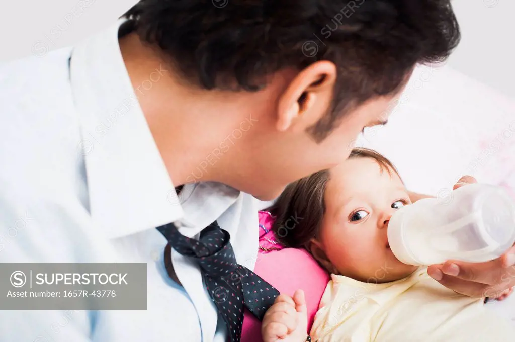 Businessman feeding his baby