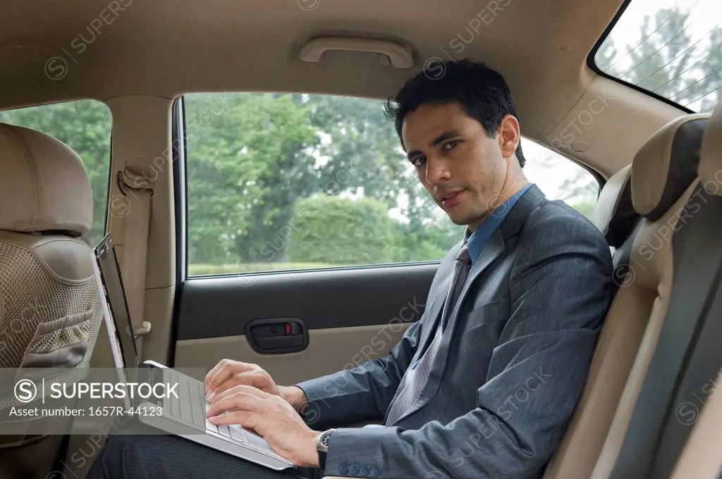 Businessman using a laptop in a car