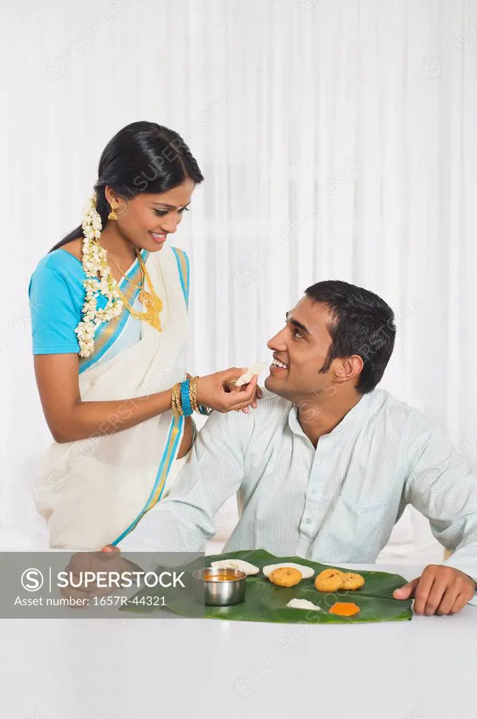 South Indian woman feeding food to her husband
