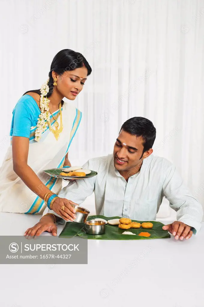 South Indian woman serving food to her husband