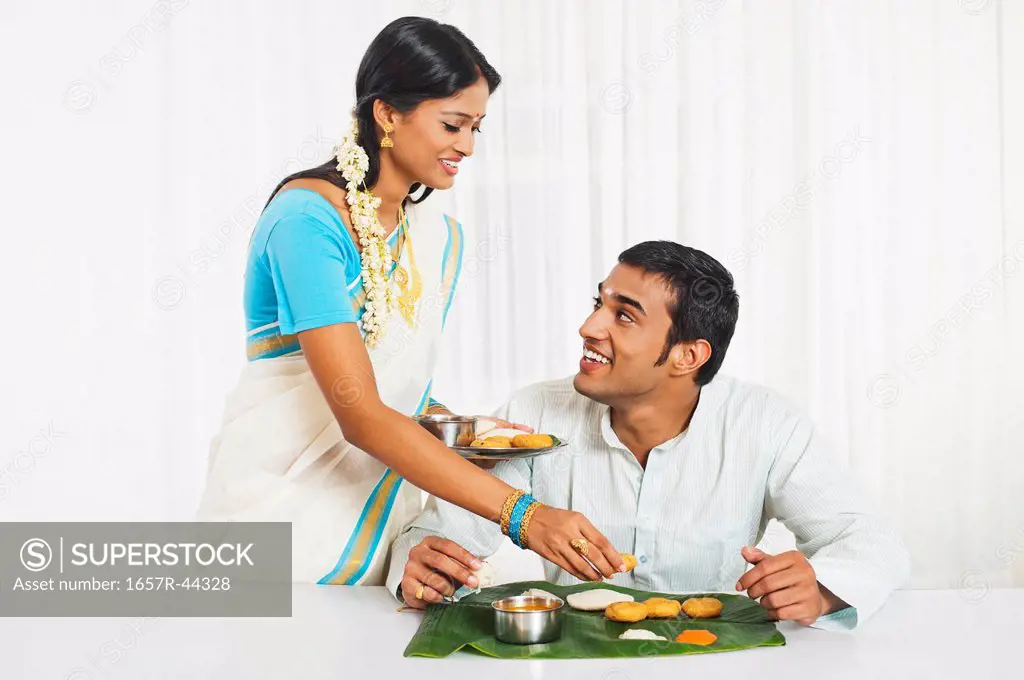 South Indian woman serving food to her husband