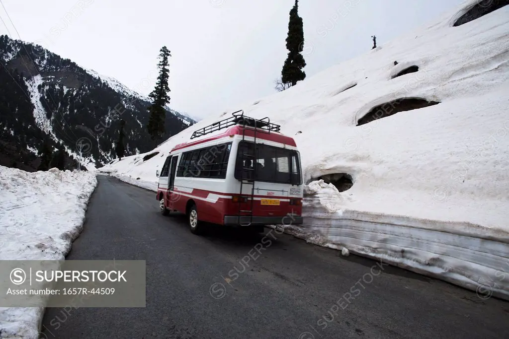 Bus moving on road in the snowy valley, Sonmarg, Jammu And Kashmir, India