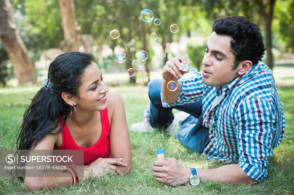 Friends blowing bubbles in a park