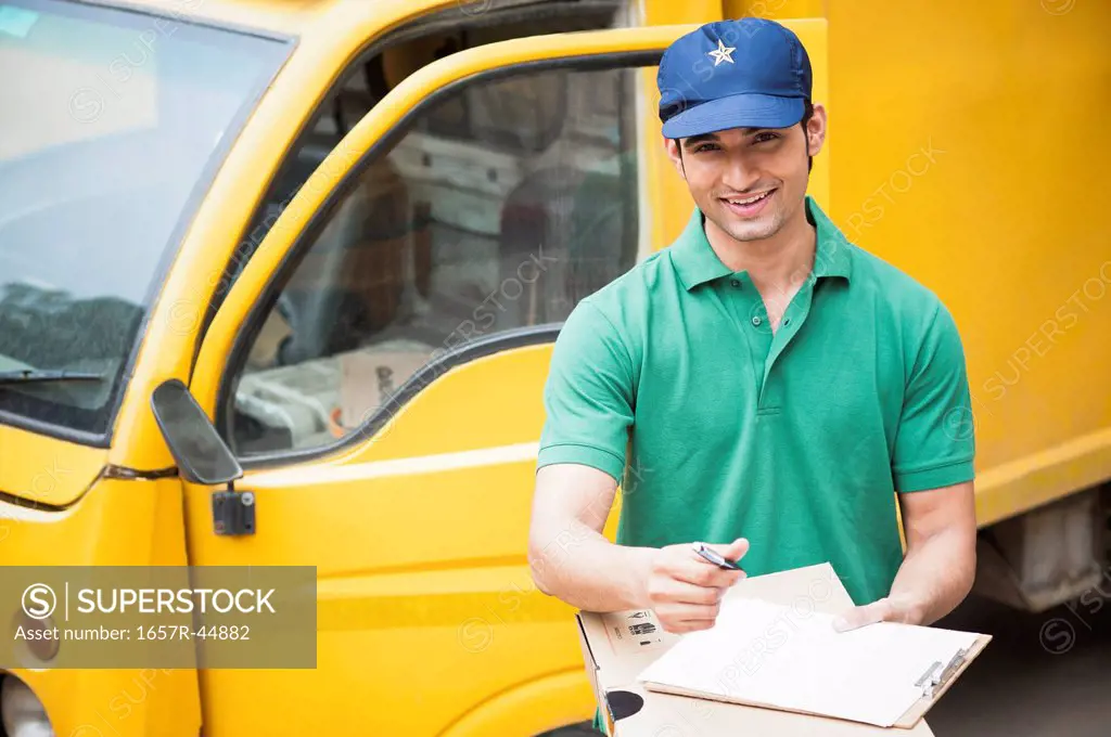 Delivery man holding cardboard boxes and smiling