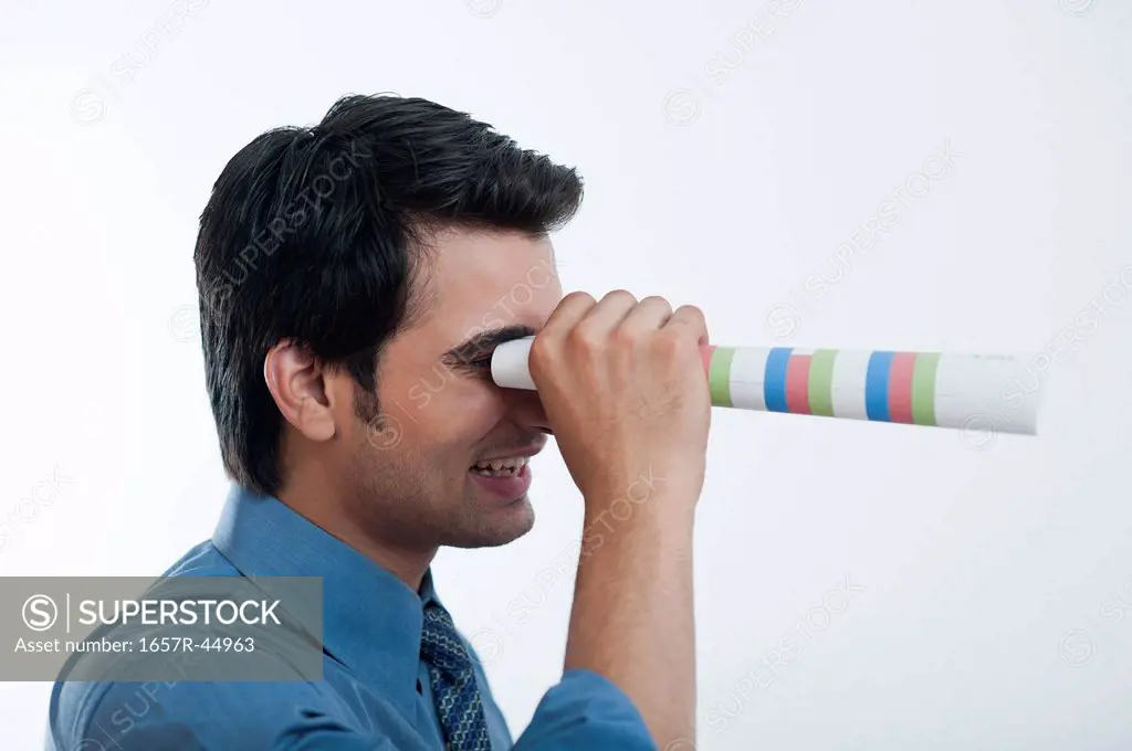 Businessman looking through from a paper binoculars