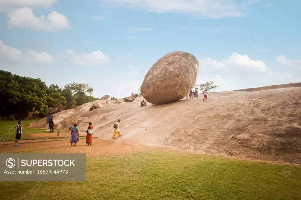 Tourists at the monument of Krishnas Butter Ball, Mahabalipuram, Kanchipuram District, Tamil Nadu, India