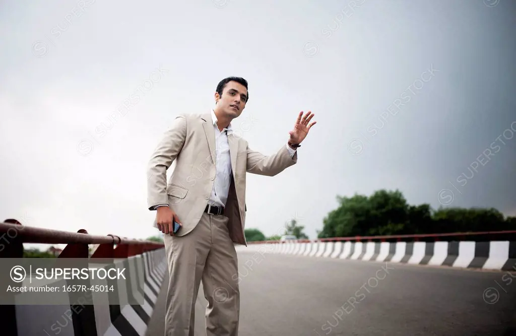 Businessman hitchhiking at the flyover