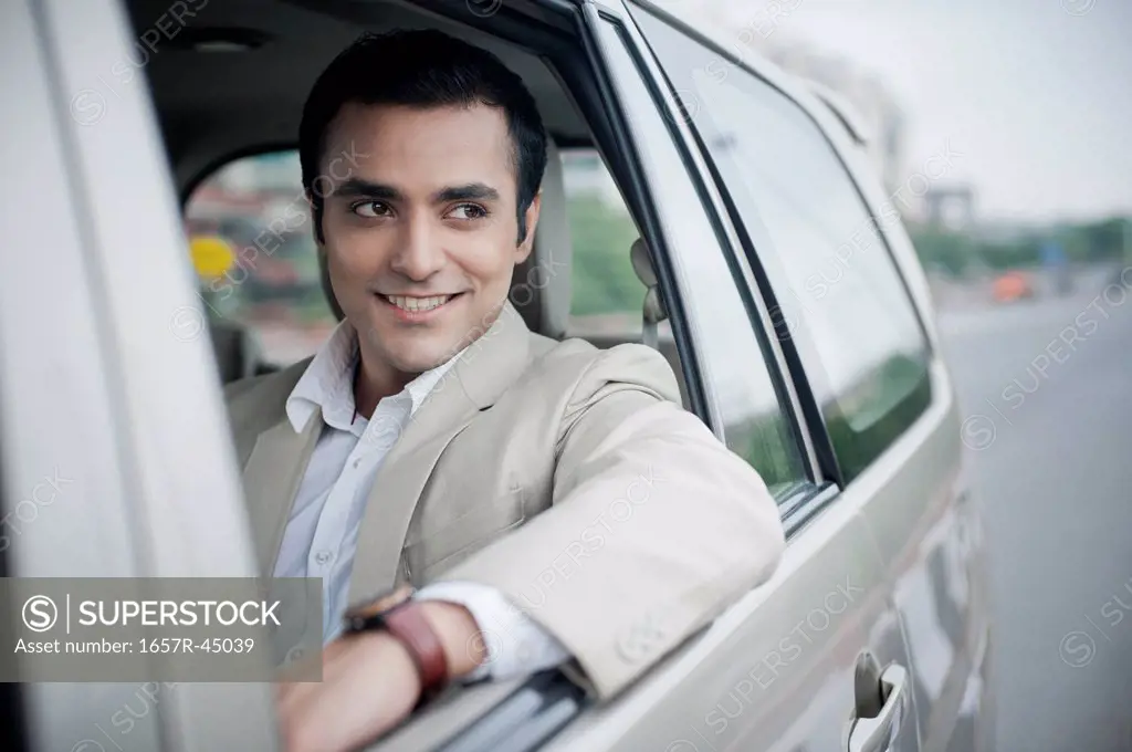 Businessman traveling in a car and smiling