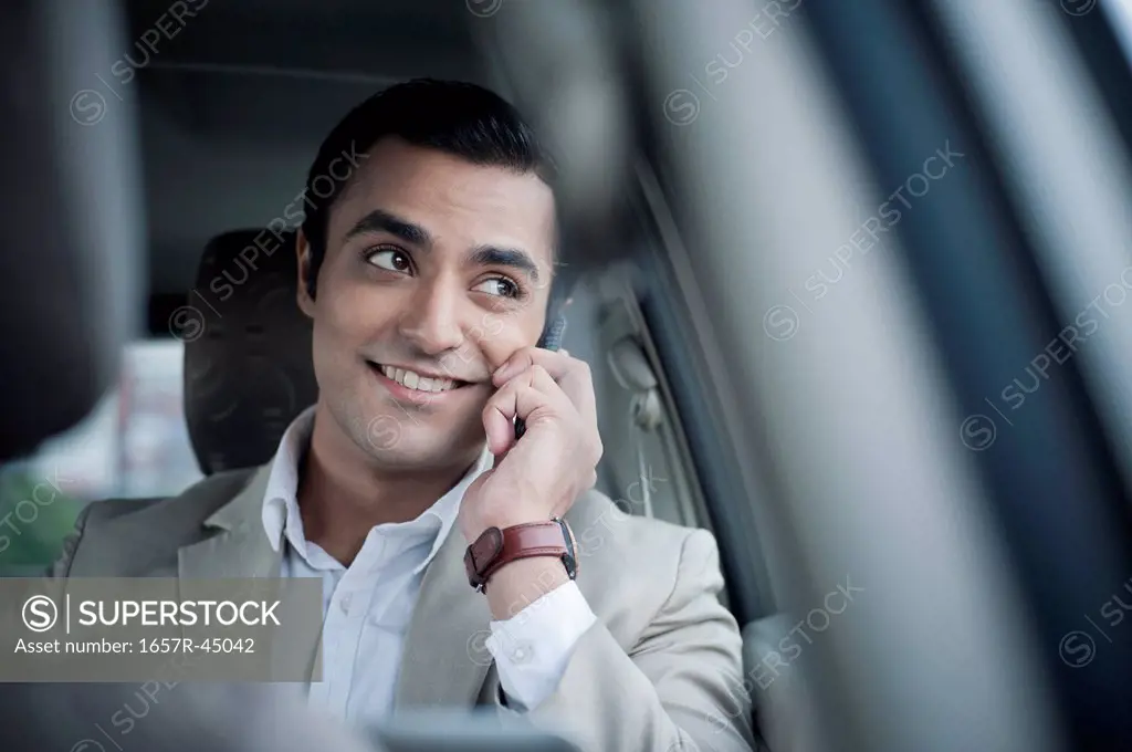Businessman talking on a mobile phone in a car