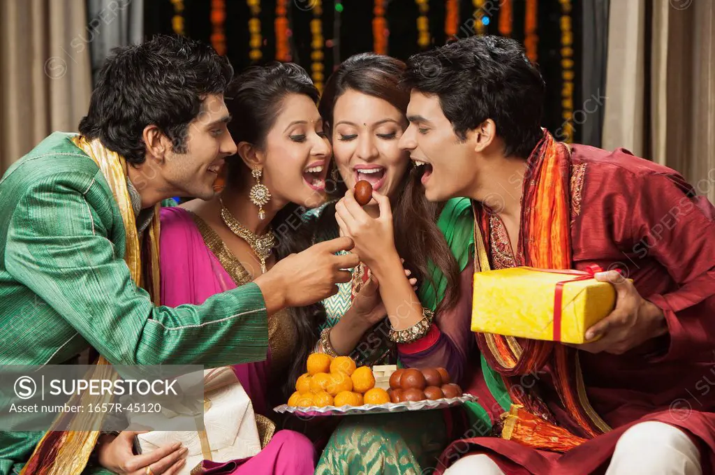 Friends eating sweets on Diwali