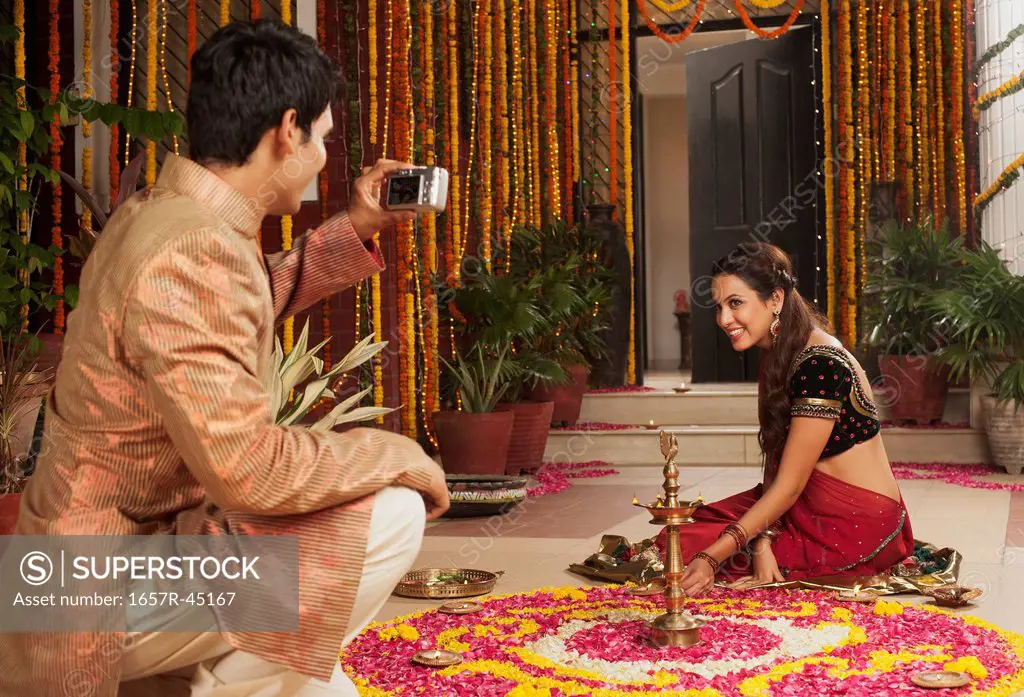 Man taking a picture of his girlfriend on Diwali