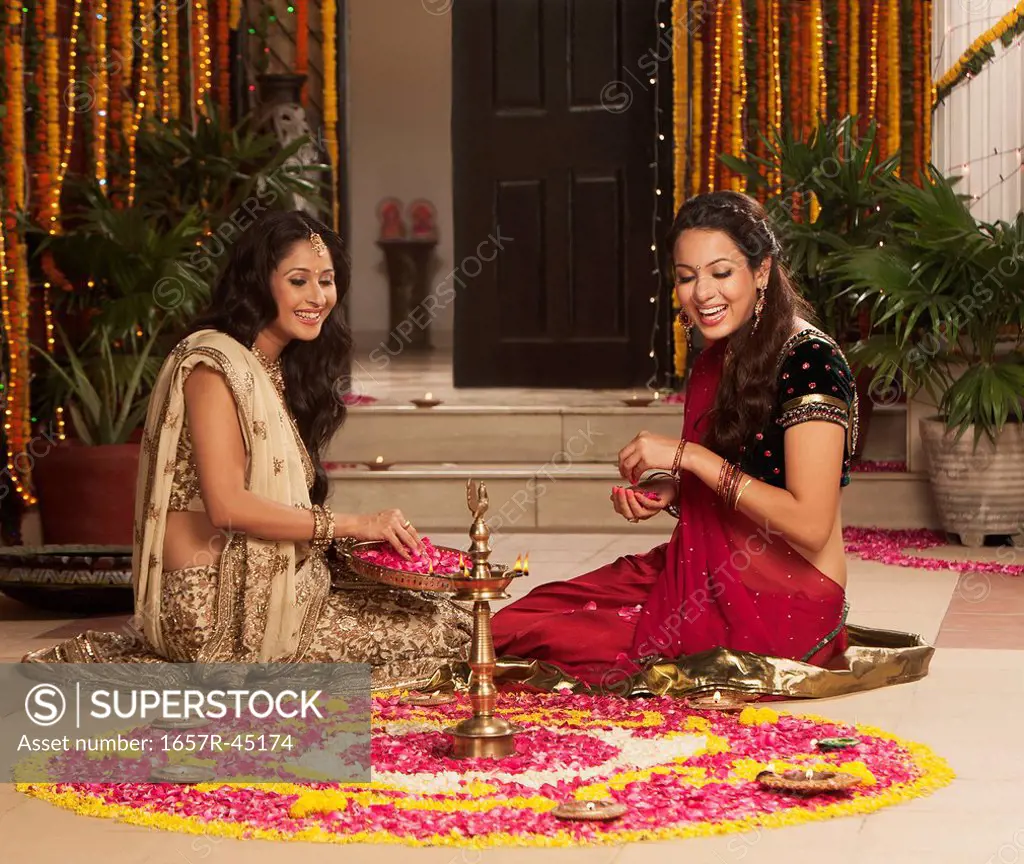 Female friends making rangoli on Diwali